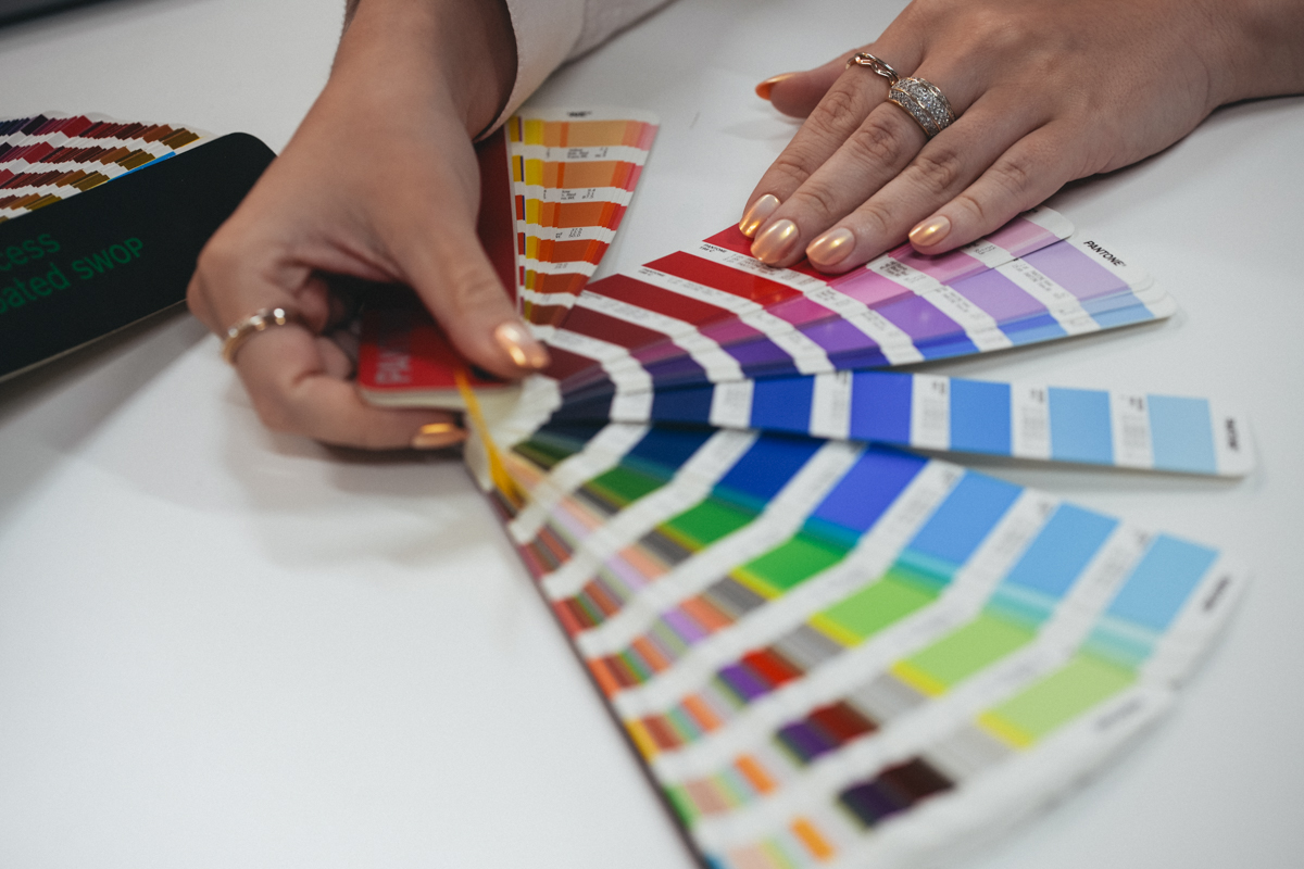 A sample booklet of pantone colors fanned out on a table.